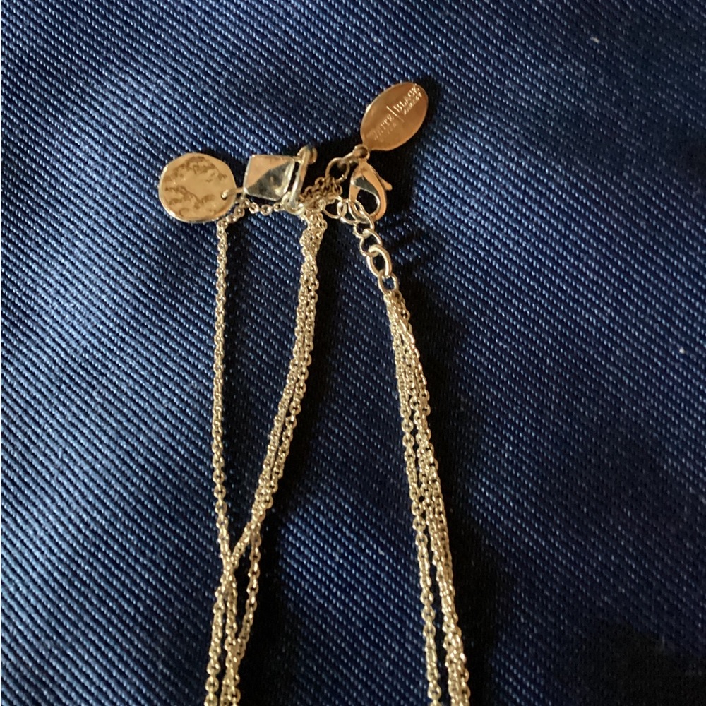 Triple strand silver necklace with varying sized discs.